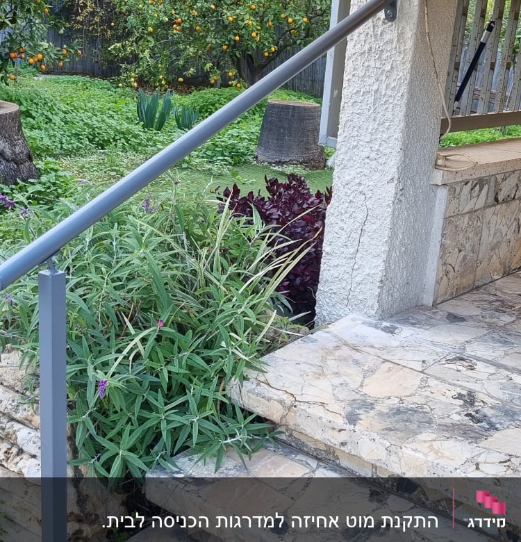מעקה מתכת אפור ליד מדרגות אבן בגינה
